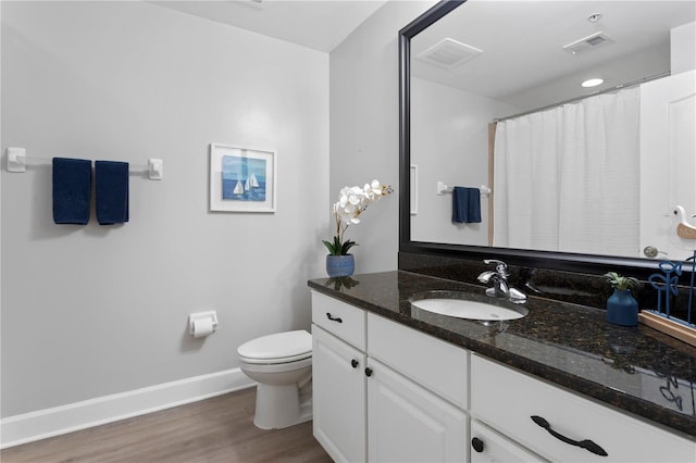 bathroom with vanity, hardwood / wood-style floors, and toilet