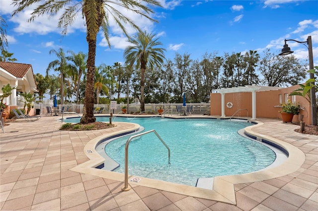 view of swimming pool with pool water feature and a patio area