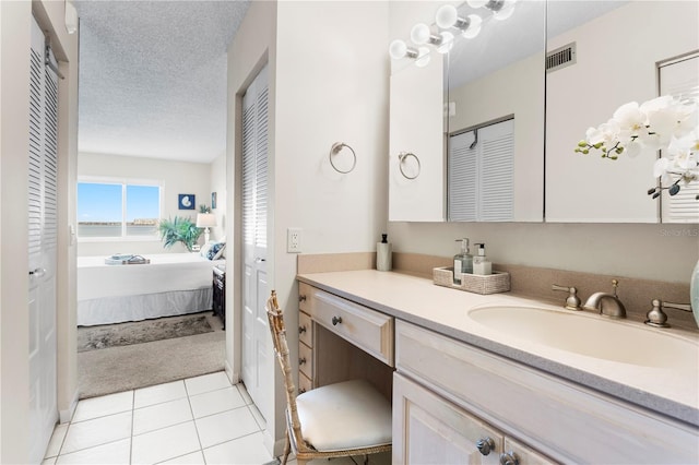 bathroom with vanity, tile patterned floors, and a textured ceiling