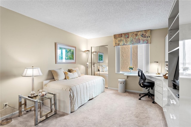 bedroom featuring light colored carpet and a textured ceiling