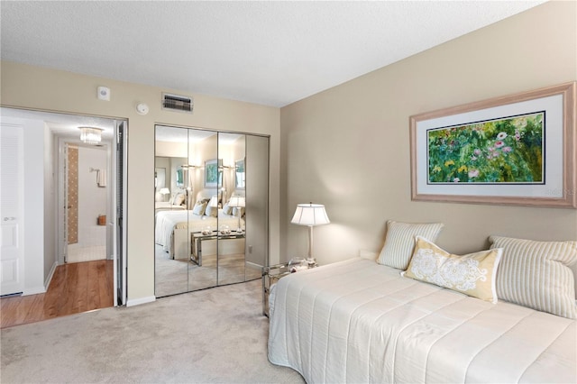 carpeted bedroom featuring a closet and a textured ceiling