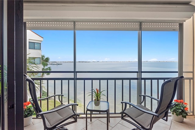 sunroom featuring a water view