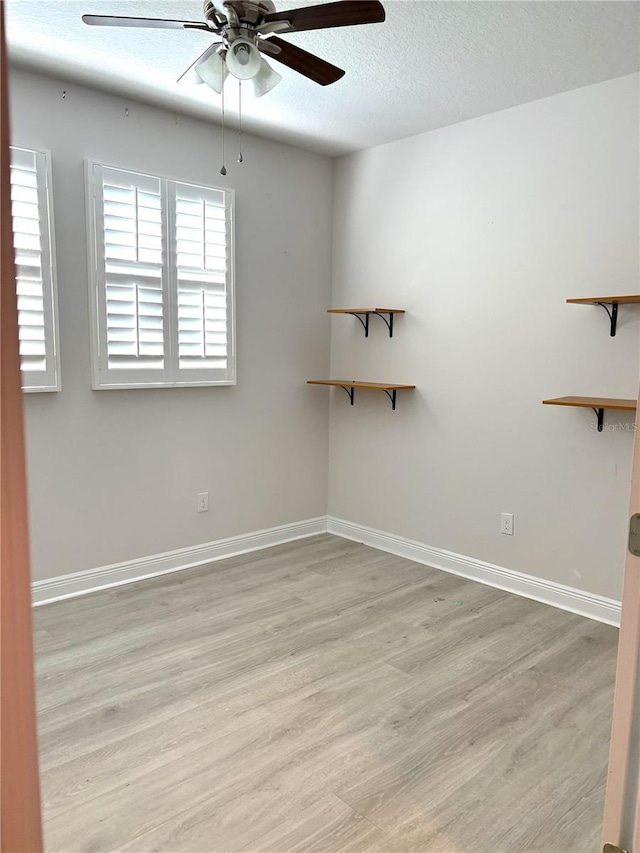 unfurnished room with ceiling fan, light hardwood / wood-style flooring, and a textured ceiling