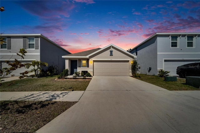 view of front of house featuring a garage and a lawn