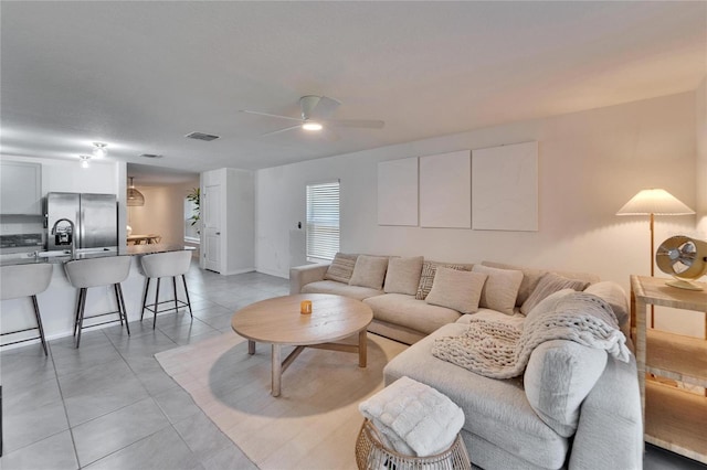 tiled living room with ceiling fan