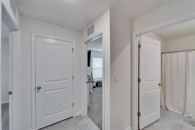 hall with light tile patterned floors