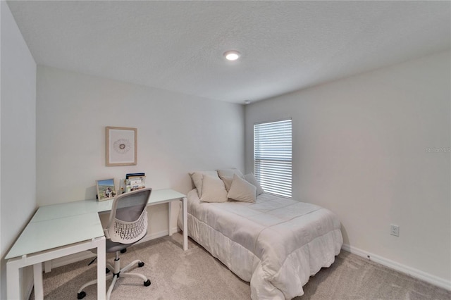 bedroom with light carpet and a textured ceiling