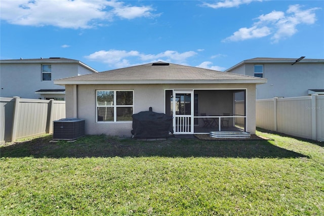 back of property with central AC unit, a lawn, and a sunroom