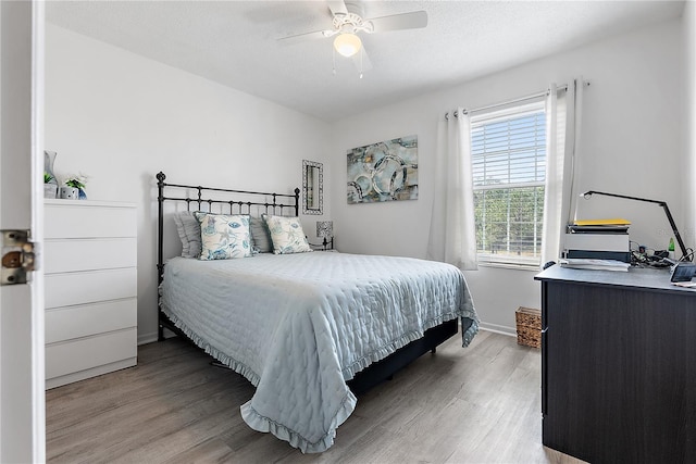 bedroom featuring a textured ceiling, ceiling fan, and light hardwood / wood-style flooring