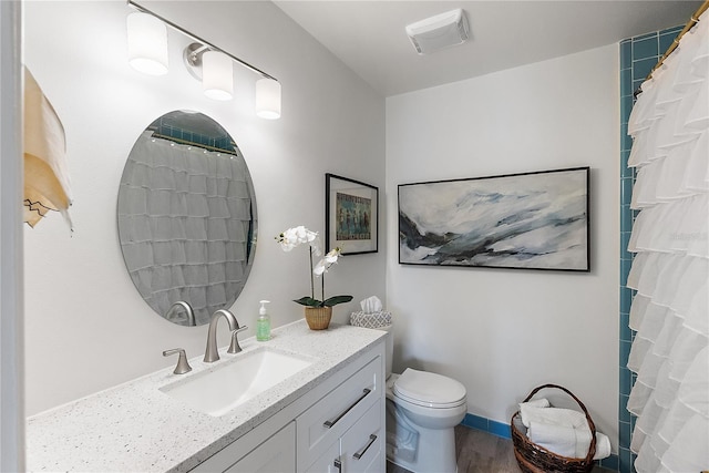 bathroom featuring vanity, hardwood / wood-style flooring, toilet, and walk in shower