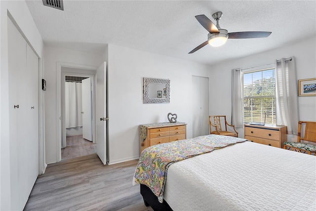 bedroom featuring ceiling fan, a closet, a textured ceiling, and light hardwood / wood-style flooring