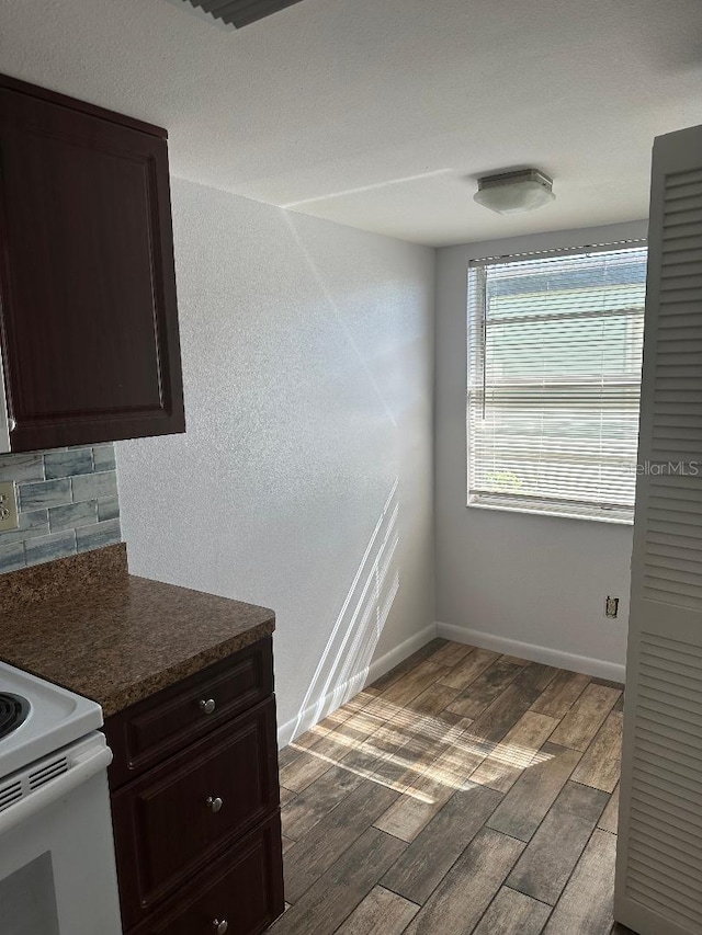 kitchen with hardwood / wood-style floors, decorative backsplash, dark brown cabinets, and white electric range