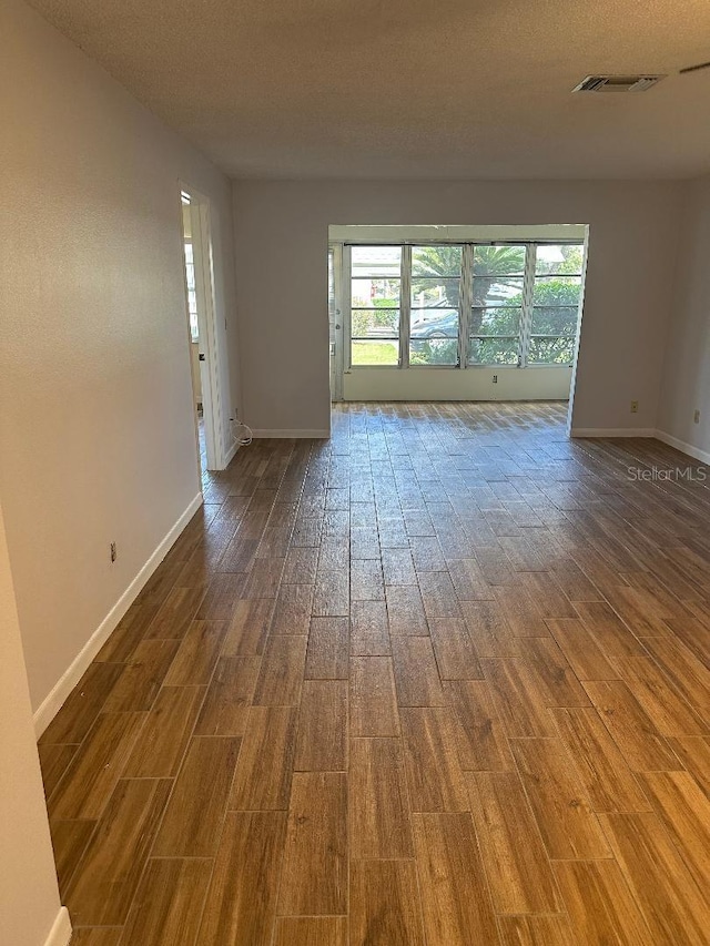 spare room with hardwood / wood-style floors and a textured ceiling