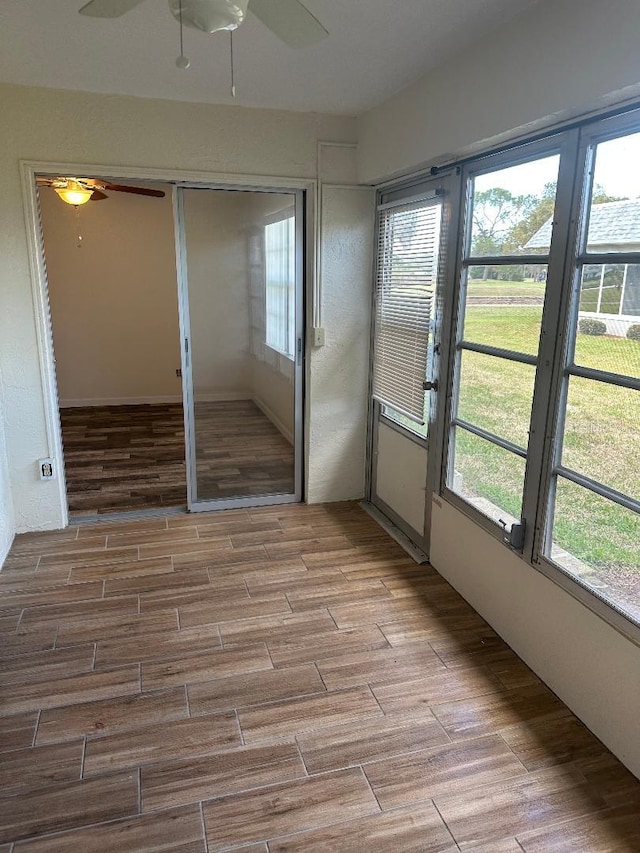 unfurnished sunroom with ceiling fan