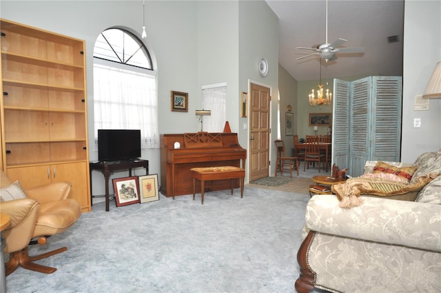 living room with ceiling fan with notable chandelier, high vaulted ceiling, and carpet flooring