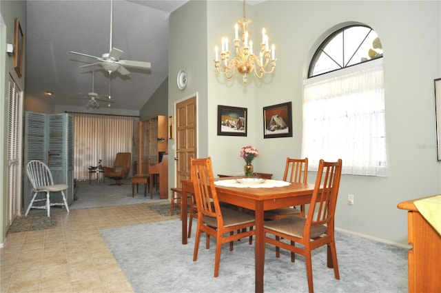 dining room featuring ceiling fan with notable chandelier and high vaulted ceiling