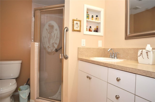 bathroom with vanity, a shower with door, and toilet