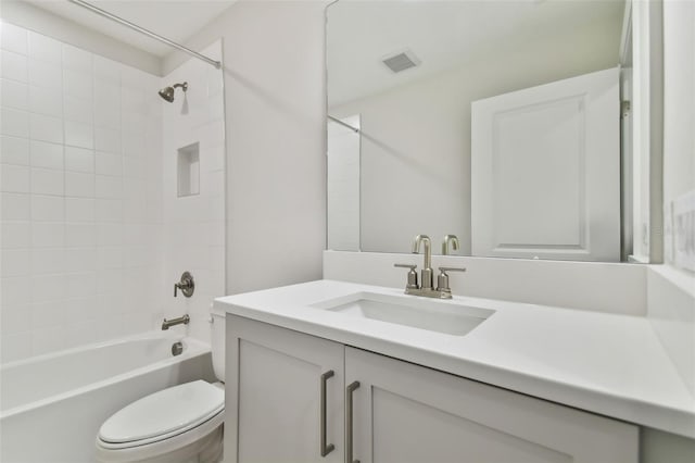 full bathroom with vanity, tiled shower / bath combo, and toilet