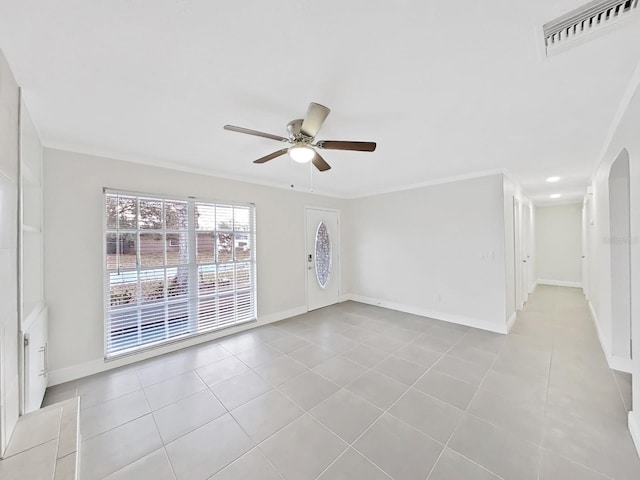 empty room with crown molding, light tile patterned floors, and ceiling fan