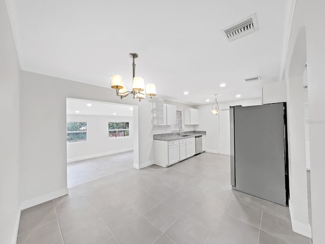 kitchen with hanging light fixtures, appliances with stainless steel finishes, sink, and white cabinets