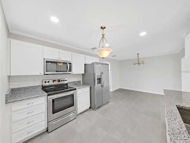 kitchen with light stone counters, decorative light fixtures, white cabinets, stainless steel appliances, and backsplash