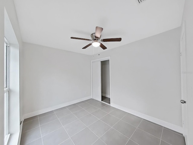 tiled empty room with ceiling fan