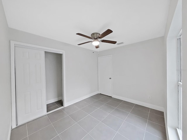 unfurnished bedroom with light tile patterned floors, a closet, and ceiling fan