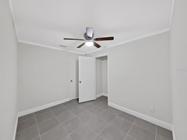 tiled spare room featuring crown molding and ceiling fan