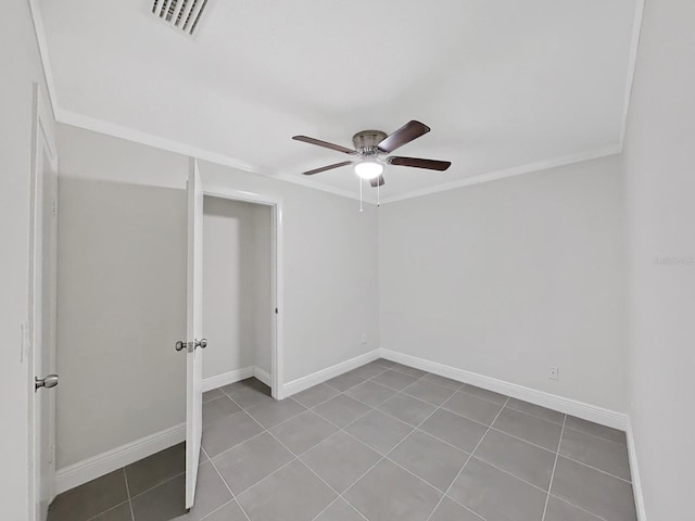 unfurnished room with ceiling fan, ornamental molding, and tile patterned flooring