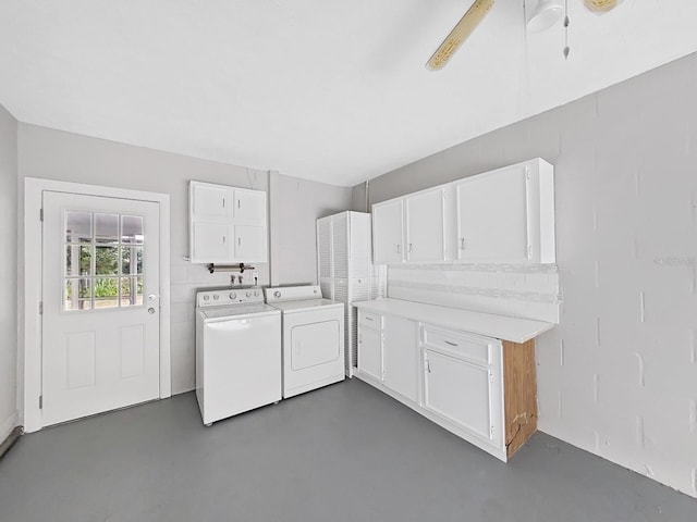 clothes washing area with ceiling fan, cabinets, and washing machine and clothes dryer