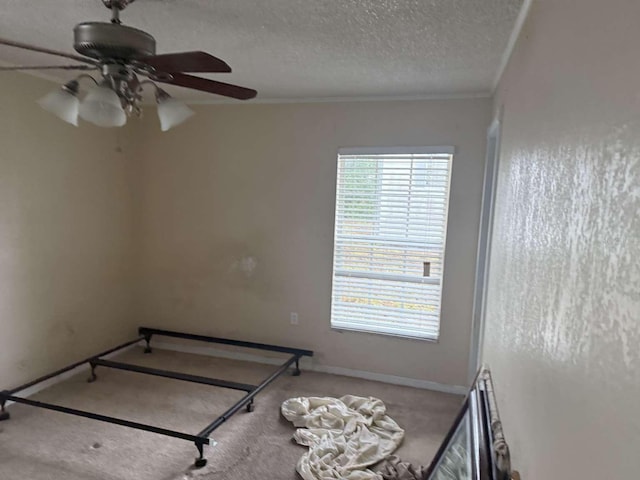 carpeted bedroom with crown molding, ceiling fan, and a textured ceiling