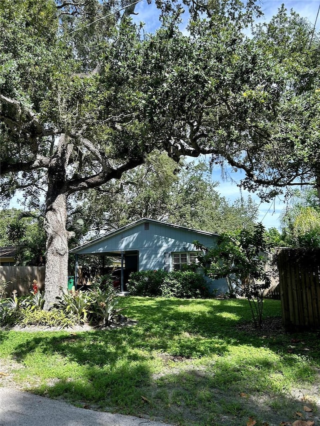 view of property exterior with a carport and a lawn