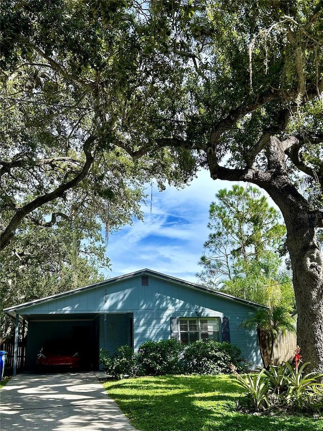 view of front of house with a carport and a front lawn