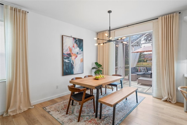 dining area featuring an inviting chandelier and light hardwood / wood-style floors