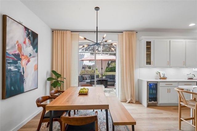 dining area featuring beverage cooler, light hardwood / wood-style floors, and a notable chandelier