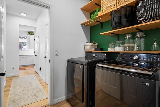 laundry room with light hardwood / wood-style floors and independent washer and dryer