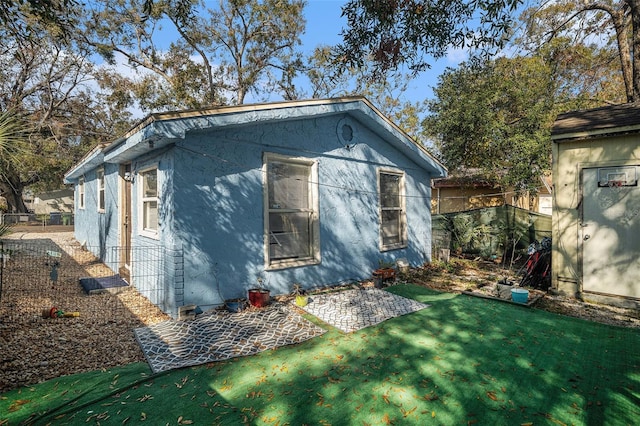 view of side of home with a patio and a yard