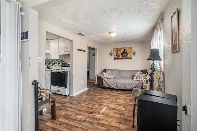 living room with dark hardwood / wood-style floors and a textured ceiling