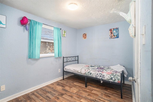 bedroom featuring dark wood-type flooring and a textured ceiling