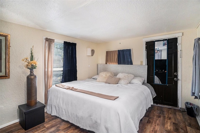 bedroom with dark wood-type flooring and a textured ceiling