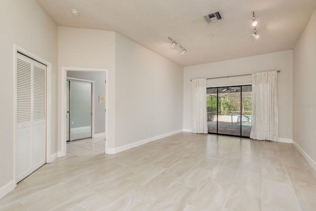 unfurnished room with rail lighting