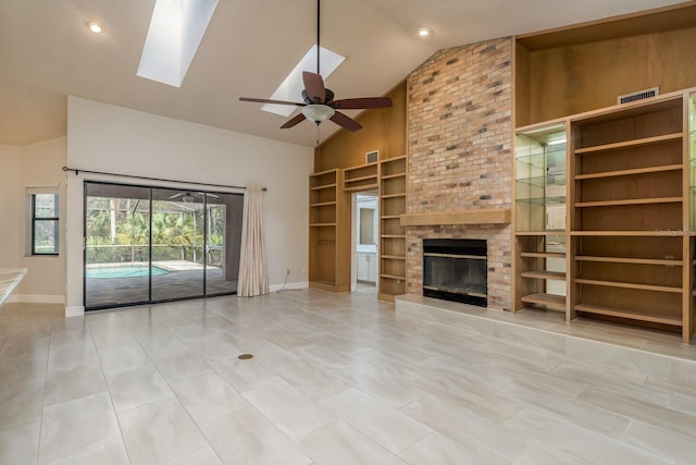 unfurnished living room featuring high vaulted ceiling, a skylight, a fireplace, ceiling fan, and built in shelves