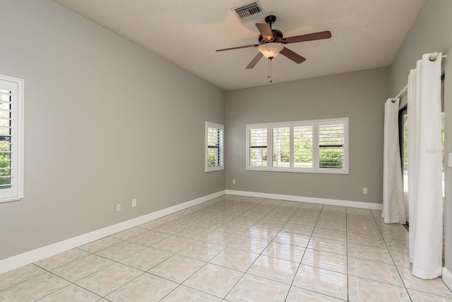 tiled empty room featuring a textured ceiling and ceiling fan