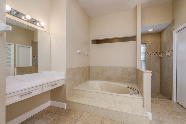 bathroom with independent shower and bath, vanity, tile patterned floors, and a textured ceiling