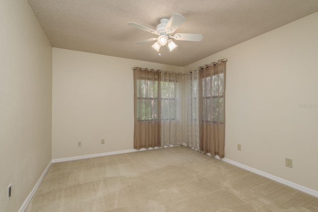 carpeted spare room featuring ceiling fan and a textured ceiling