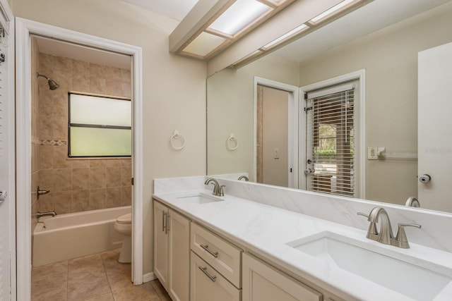 full bathroom featuring tile patterned flooring, vanity, tiled shower / bath combo, and toilet