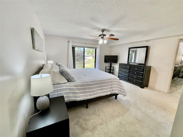 carpeted bedroom featuring ceiling fan and a textured ceiling