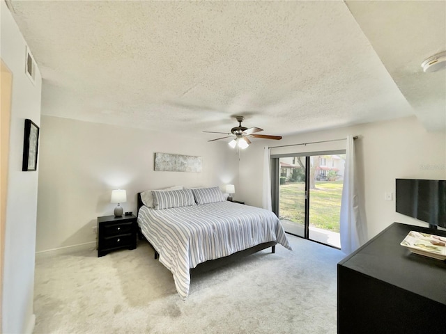 bedroom with light carpet, access to exterior, a textured ceiling, and ceiling fan