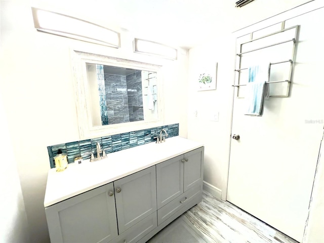 bathroom with hardwood / wood-style flooring, vanity, and backsplash