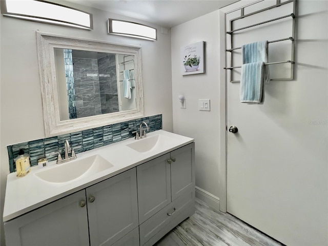 bathroom with vanity, hardwood / wood-style floors, and decorative backsplash